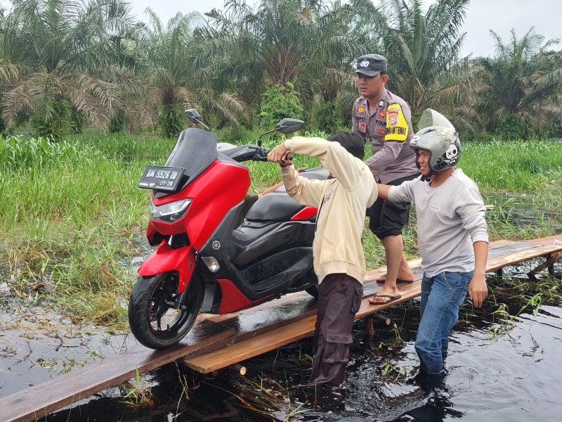 Demi membantu masyarakat agar dapat melintas akses jalan tersebut Bhabinkamtibmas polsubsektor Kelurahan Pelalawan terjun langsung kelokasi jalan