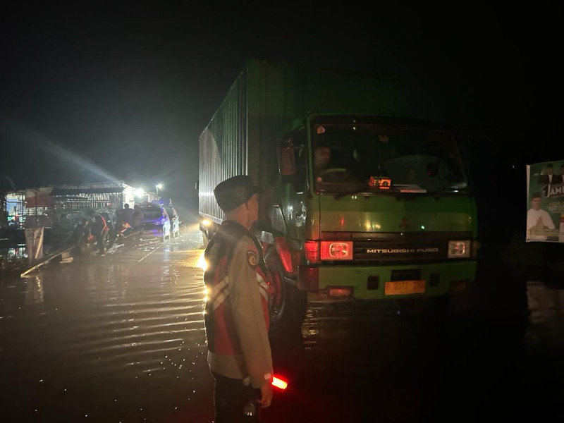 Polsubsektor Pelalawan bersama personil gabungan dari Polres non stop 24 jam mengantisipasi terjadinya kemacetan akibat genangan air di badan jalan