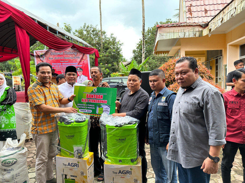 Didampingi Anggota DPRD Pelalawan, Bupati Pelalawan serahkan bantuan Buku Pupuk dan  alat pertanian