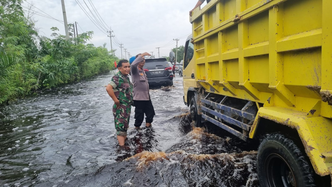 Kapolsubsektor Pelalawan Iptu Legito dan Danramil 03 Bunut Kapt Inf Muhammad Yusuf melakukan pengaturan arus lalu lintas